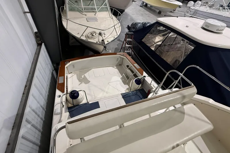 Slide: The Image of 1973 Bertram 28 Flybridge Cruiser in storage, showcasing spacious deck and seating area. - 7
