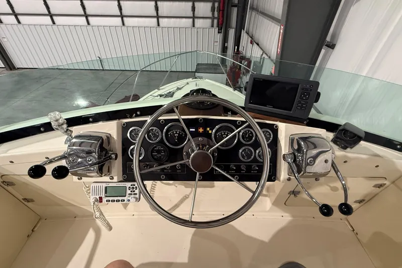 Slide: The Image of 1973 Bertram 28 Flybridge Cruiser helm with steering wheel, gauges, and navigation equipment. - 5