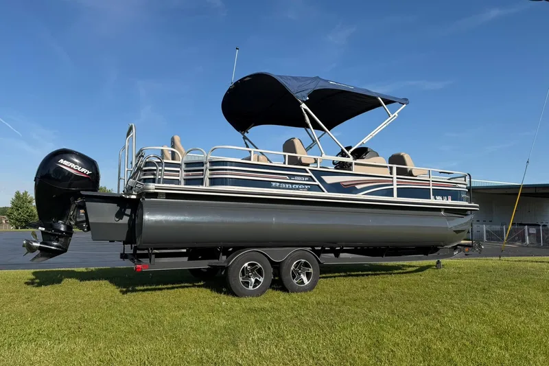 Slide: The Image of 2021 Ranger Reata 223F pontoon boat on trailer, featuring Mercury outboard motor. - 1