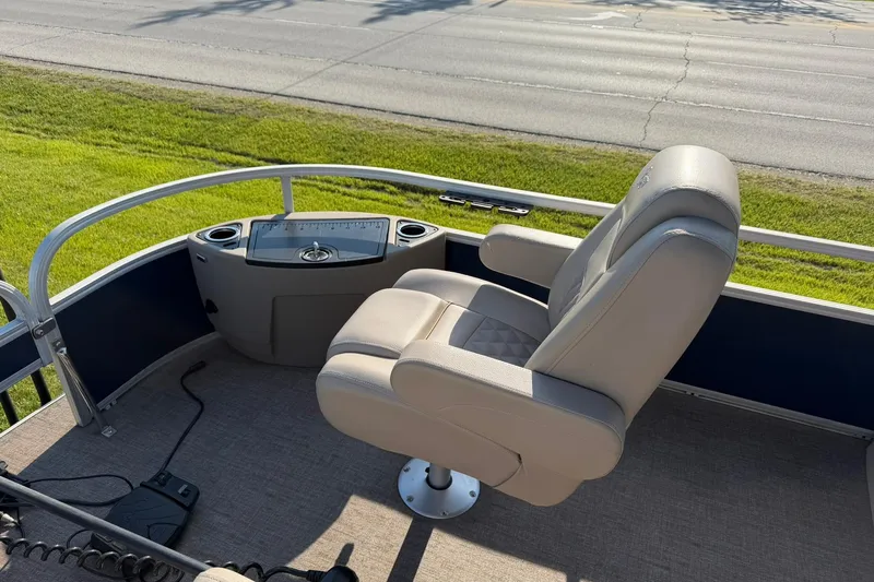 Slide: The Image of Captain's chair on 2021 Ranger Reata 223F boat, featuring a control panel and cup holders. - 11