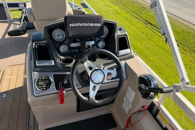 Slide: The Image of 2021 Ranger Reata 223F boat dashboard with steering wheel and Humminbird electronics. - 13