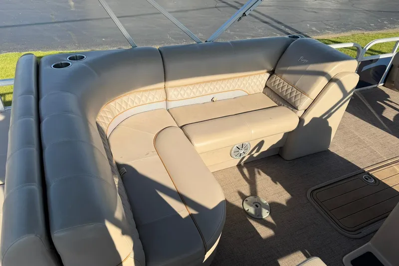 Slide: The Image of Luxurious seating on 2021 Ranger Reata 223F boat, featuring beige upholstery and cup holders. - 16