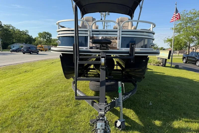 Slide: The Image of 2021 Ranger Reata 223F pontoon boat on trailer, parked on grass near road. - 4