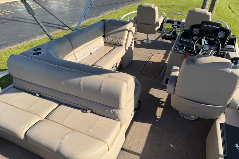 Slide: The Image of 2021 Ranger Reata 223F boat interior with beige seating and steering console. - 6