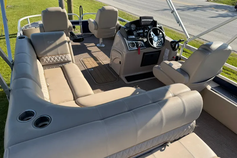 Slide: The Image of Interior of a 2021 Ranger Reata 223F boat with beige seating and steering console. - 7