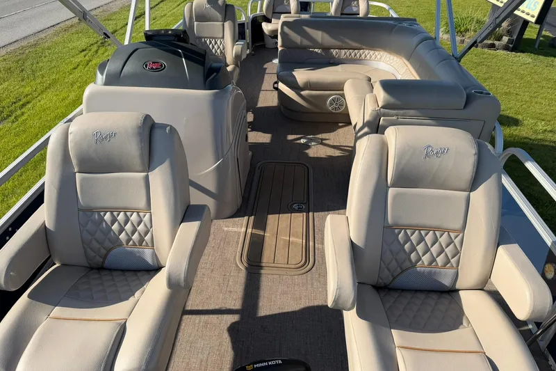 Slide: The Image of 2021 Ranger Reata 223F boat interior with plush seating and steering console. - 9