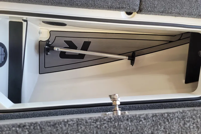 Slide: The Image of 2023 Ranger Z521R boat storage compartment with rod holder and carpeted interior. - 11