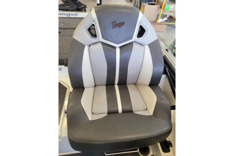 Slide: The Image of 2023 Ranger Z521R boat seat with gray and white upholstery in a workshop setting. - 14