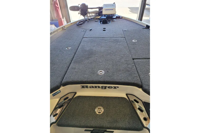 Slide: The Image of 2023 Ranger Z521R boat deck with carpeted surface and fishing equipment. - 5