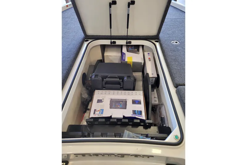 Slide: The Image of Open storage compartment in 2023 Ranger Z521R boat, containing electronic equipment and accessories. - 8