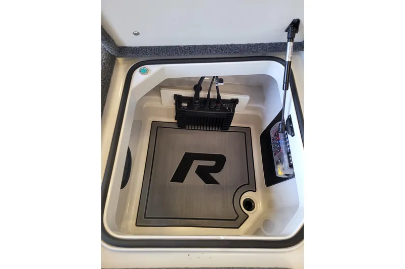 Slide: The Image of 2023 Ranger Z521R boat storage compartment with electronic equipment and branded mat. - 9