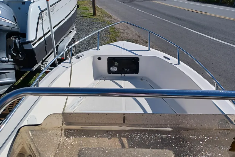 Slide: The Image of 2005 Key West 1900 Center Console boat parked near a road, showcasing bow area. - 13