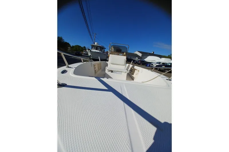 Slide: The Image of 2005 Key West 1900 Center Console boat with white deck and seating, parked outdoors. - 8