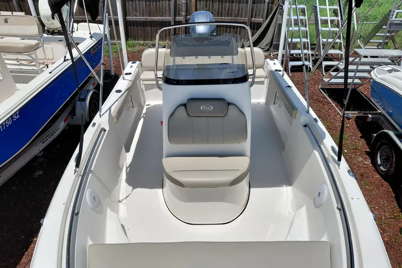 Slide: The Image of 2023 Key West 189 FS boat interior with seating and console, parked outdoors. - 11