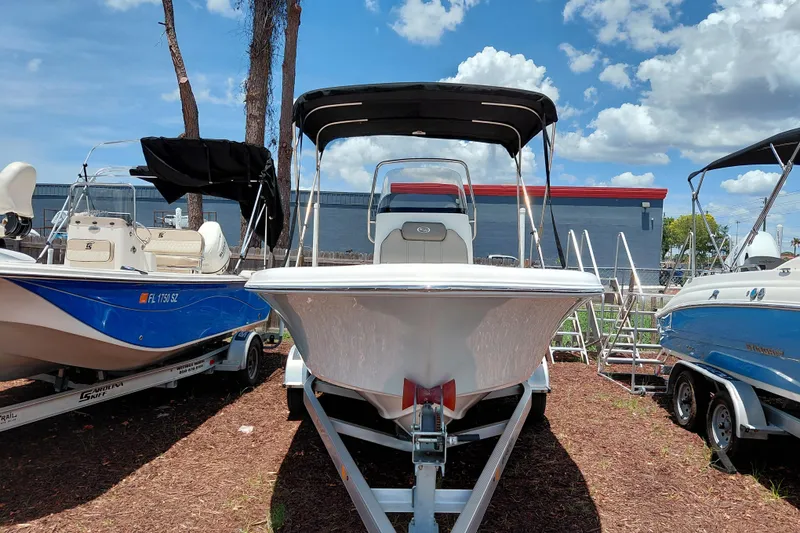 Slide: The Image of 2023 Key West 189 FS boat displayed outdoors, flanked by other boats under a sunny sky. - 2