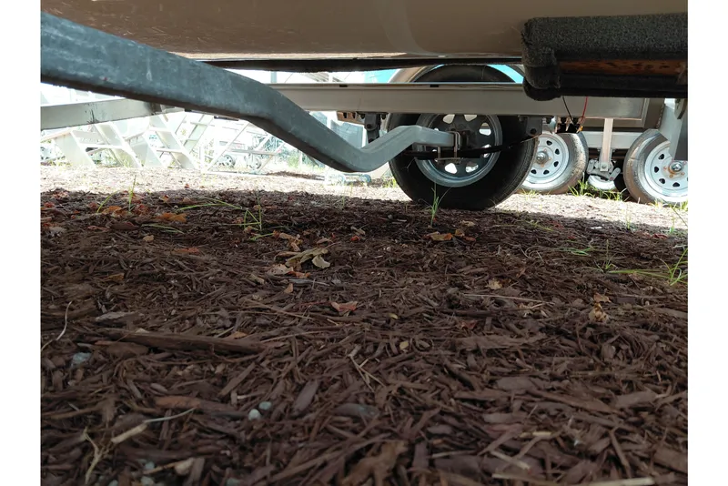 Slide: The Image of Underneath view of a 2023 Key West 189 FS boat trailer on mulch ground. - 38