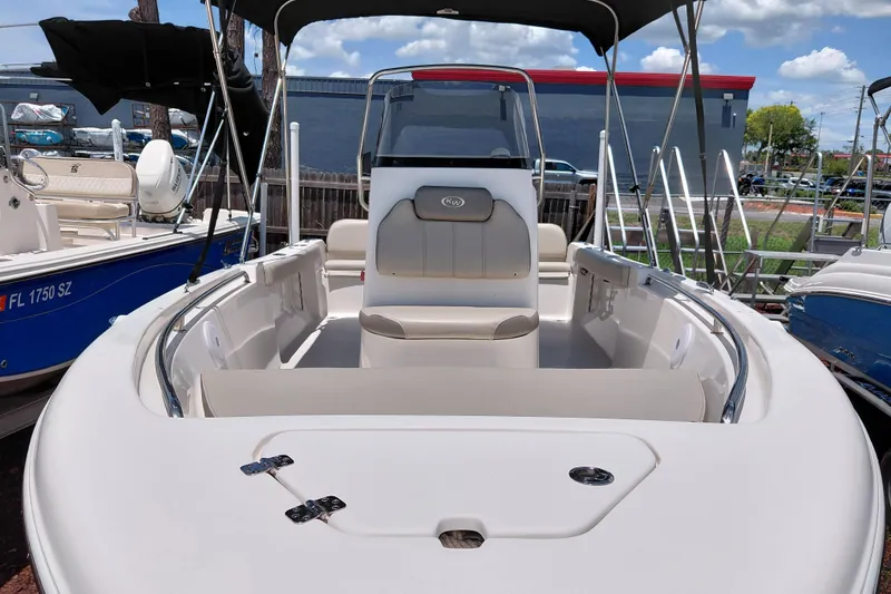 Slide: The Image of 2023 Key West 189 FS boat interior with seating and canopy under blue sky. - 9