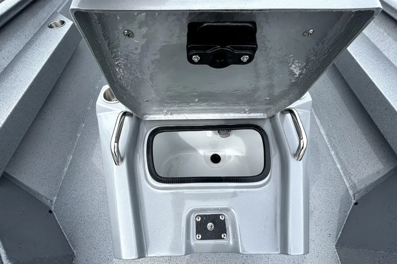 Slide: The Image of Open storage compartment on 2026 Xpress H20B Bay boat, featuring stainless steel handles. - 24