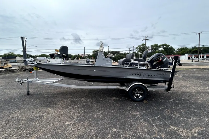 Slide: The Image of 2026 Xpress H20B Bay boat on trailer, parked outdoors, side view. - 4