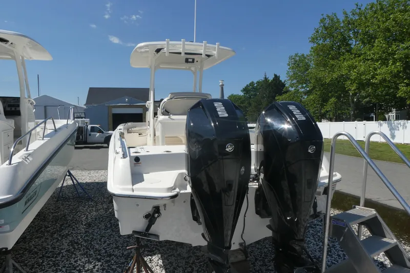 Slide: The Image of 2019 Boston Whaler 270 Dauntless with dual outboard engines, parked outdoors. - 1