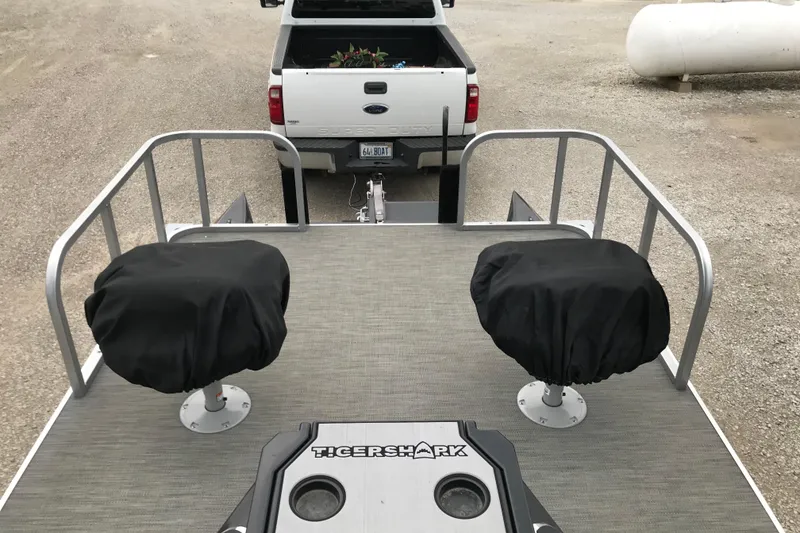 Slide: The Image of 2024 Tigershark 700 12' Mini Pontoon with covered seats, parked behind a truck. - 10