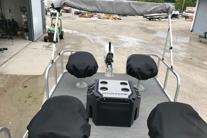 Slide: The Image of 2024 Tigershark 700 12' Mini Pontoon with covered seats and central console. - 12
