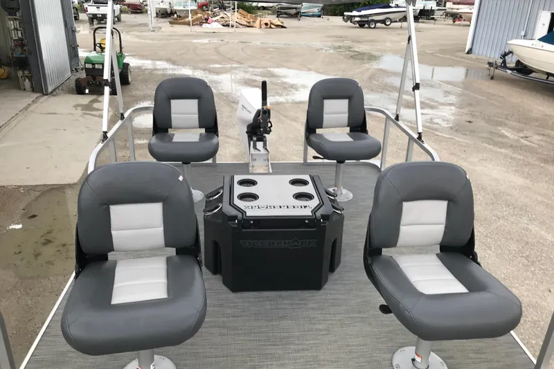 Slide: The Image of 2024 Tigershark 700 12' Mini Pontoon with four gray seats and central console. - 6