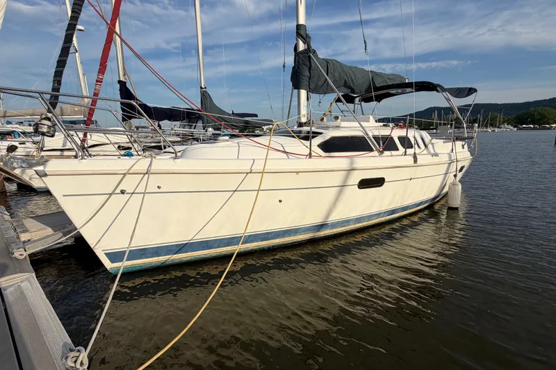 The Image of 2000 Hunter 310 sailboat docked at marina under clear blue sky. - 0
