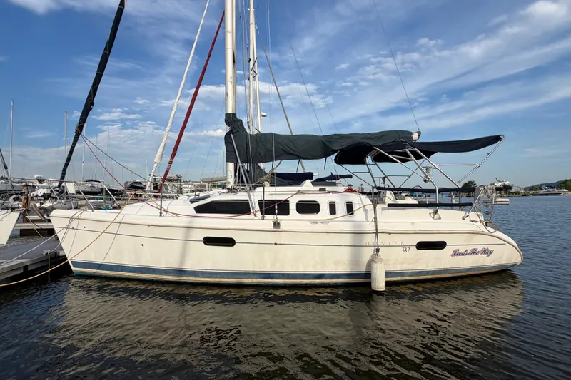 Slide: The Image of Sailboat Hunter 310, 2000 model, docked at marina under clear blue sky. - 1