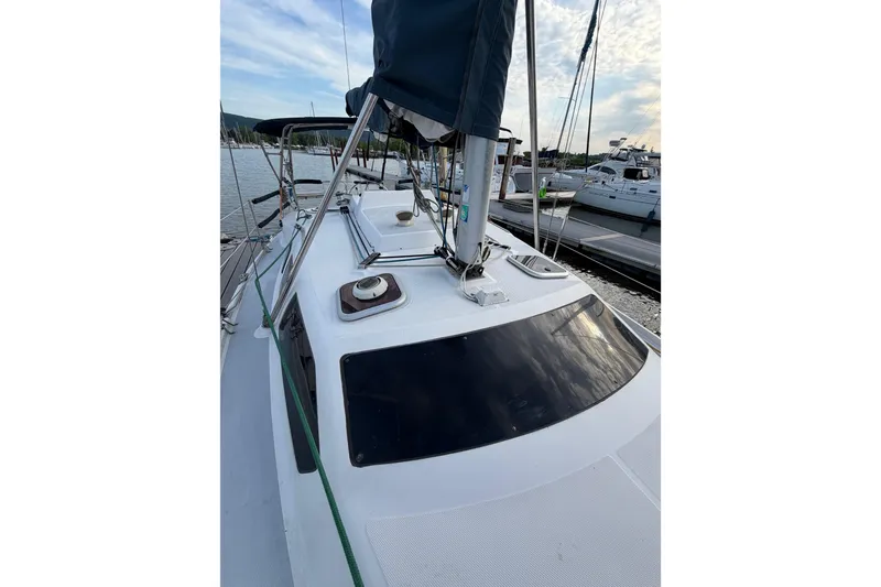 Slide: The Image of 2000 Hunter 310 sailboat docked at marina, showcasing deck and rigging. - 31