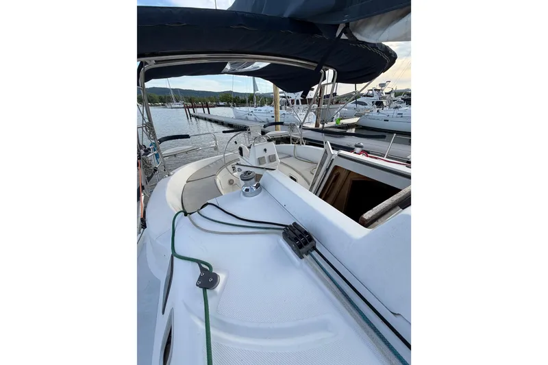 Slide: The Image of Sailboat Hunter 310, 2000 model, docked at marina with visible cockpit and helm. - 33