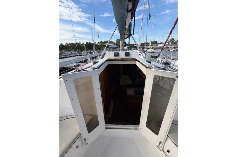 Slide: The Image of Hunter 310 sailboat cockpit view, 2000 model, docked at marina under blue sky. - 35