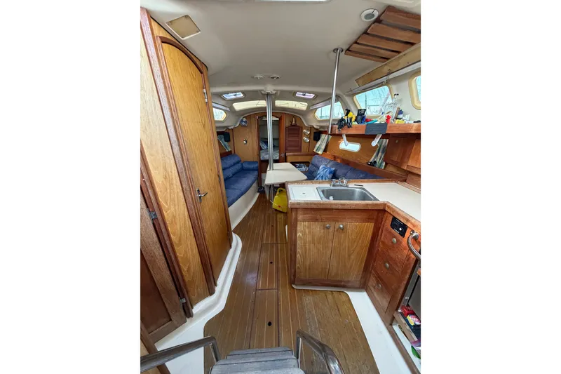 Slide: The Image of Interior of a 2000 Hunter 310 sailboat with wooden cabinetry and seating area. - 37