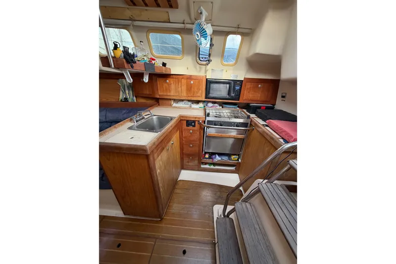 Slide: The Image of Interior of a 2000 Hunter 310 sailboat kitchen with wooden cabinetry and appliances. - 38