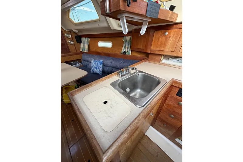 Slide: The Image of Interior of 2000 Hunter 310 sailboat with wooden cabinetry and compact kitchen area. - 39