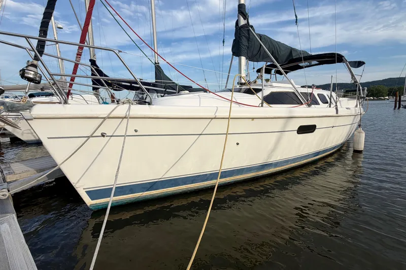Slide: The Image of 2000 Hunter 310 sailboat docked at marina under clear sky. - 4