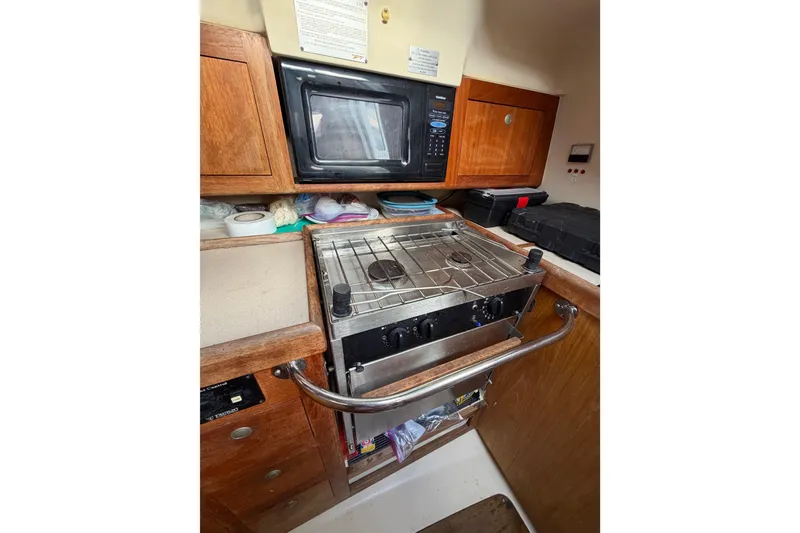 Slide: The Image of Compact kitchen area in a 2000 Hunter 310 sailboat with stove and microwave. - 40