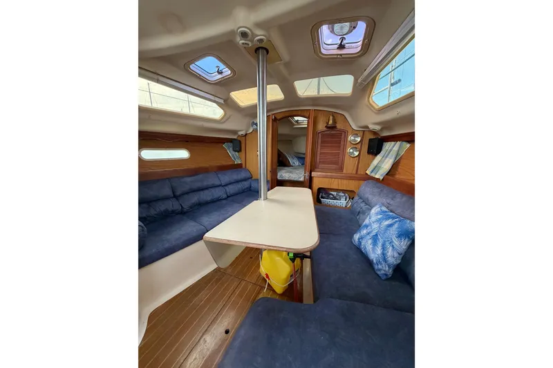 Slide: The Image of Interior of 2000 Hunter 310 sailboat with cozy seating and wooden accents. - 44