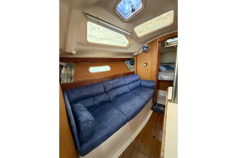 Slide: The Image of Interior of 2000 Hunter 310 sailboat with blue sofa and cozy cabin space. - 45