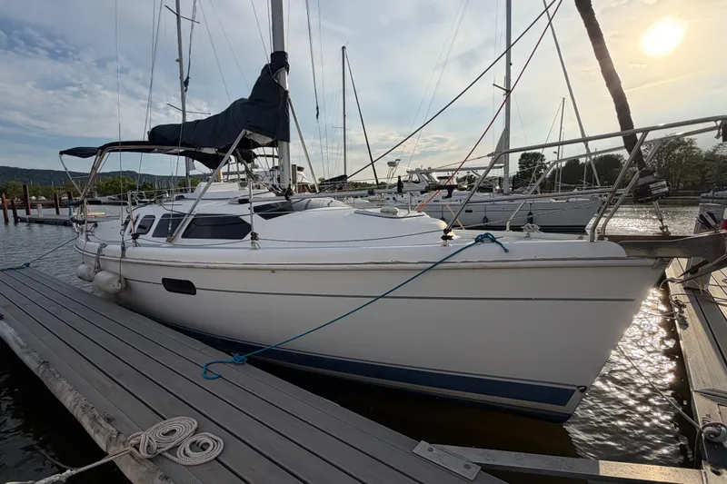 Slide: The Image of 2000 Hunter 310 sailboat docked at marina under a clear sky. - 5