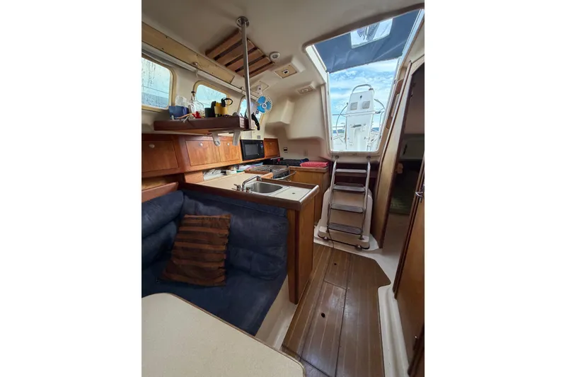 Slide: The Image of Interior of a 2000 Hunter 310 sailboat with cozy seating and compact kitchen area. - 55