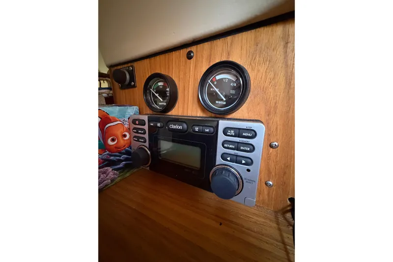 Slide: The Image of Control panel of a 2000 Hunter 310 boat with gauges and Clarion stereo system. - 59
