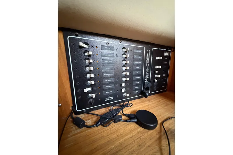 Slide: The Image of Electrical control panel of a 2000 Hunter 310 boat, featuring various switches and indicators. - 60