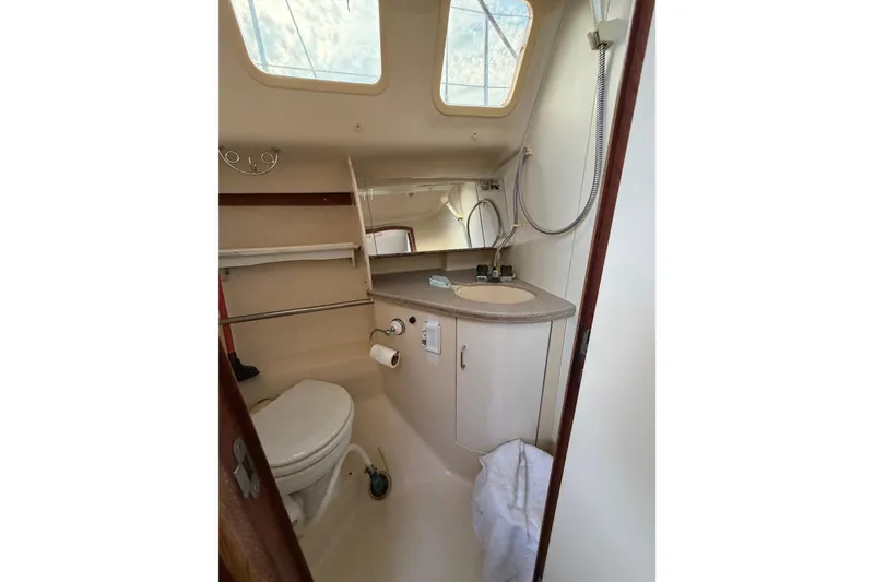Slide: The Image of Compact bathroom in a 2000 Hunter 310 sailboat with toilet, sink, and shower. - 63