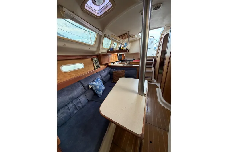 Slide: The Image of Interior of a 2000 Hunter 310 sailboat with cozy seating and wooden accents. - 70