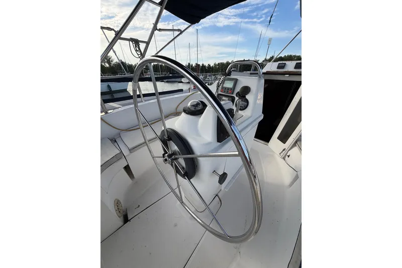 Slide: The Image of Steering wheel of a 2000 Hunter 310 sailboat, docked at a marina. - 8