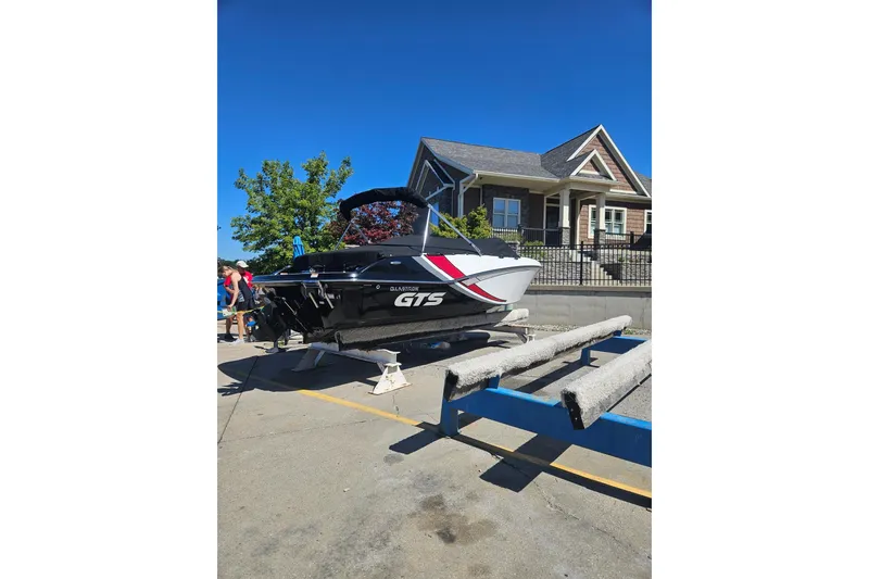 Slide: The Image of 2021 Glastron GTS 205 boat on trailer near a house, sunny day. - 1