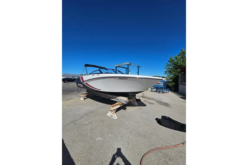Slide: The Image of 2021 Glastron GTS 205 boat on stands under clear blue sky. - 2