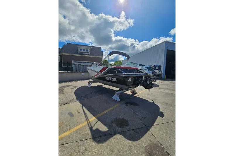 Slide: The Image of 2021 Glastron GTS 205 boat on a sunny day, parked outside a garage. - 3