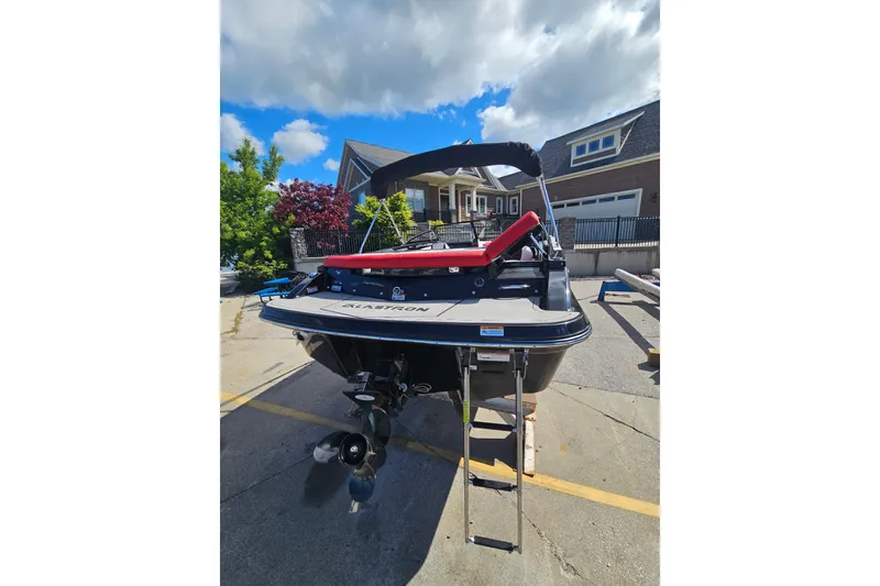 Slide: The Image of 2021 Glastron GTS 205 boat with ladder, parked outdoors under a cloudy sky. - 4